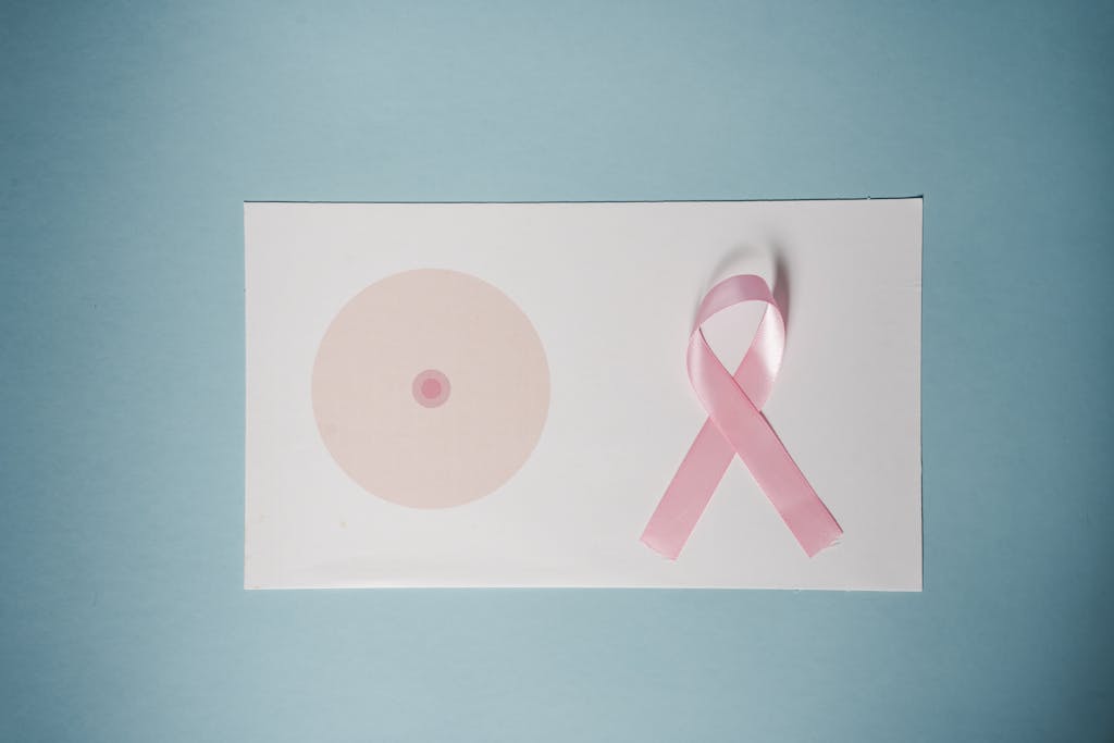 Breast cancer awareness concept with pink ribbon on pastel background.